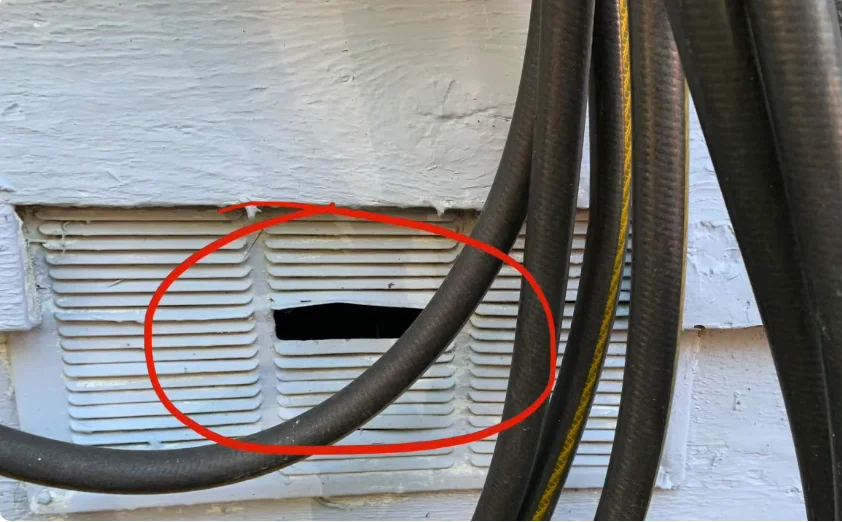 Broken foundation vent under an older raised house