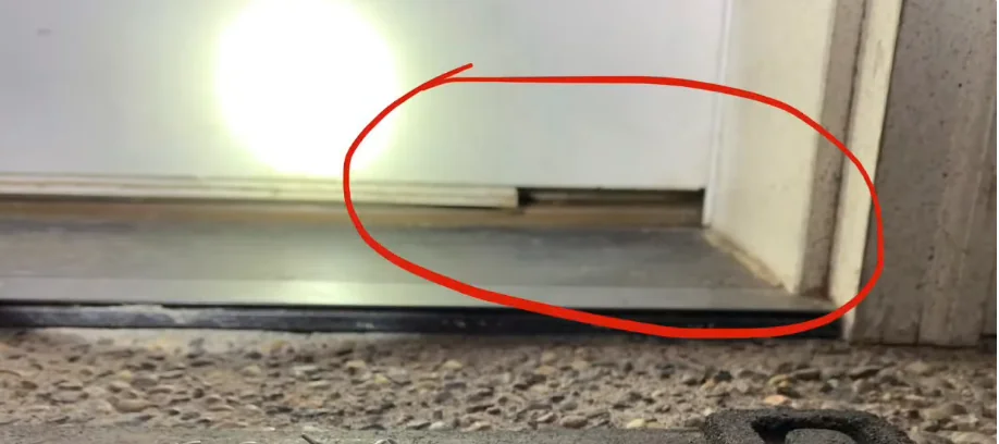 Gap at the bottom corner of a garage door where mice get inside