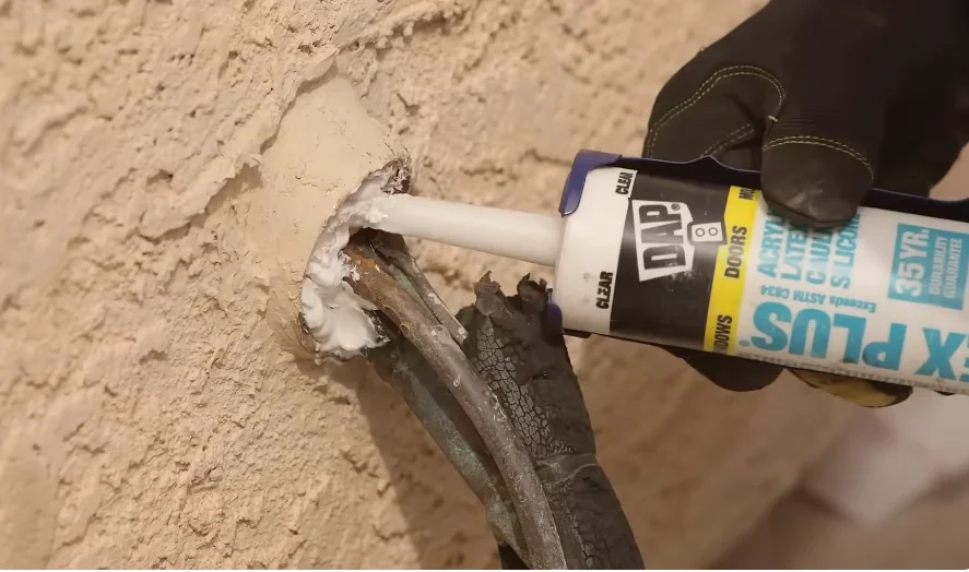 Gap around a pipe entering an exterior wall being sealed against mice